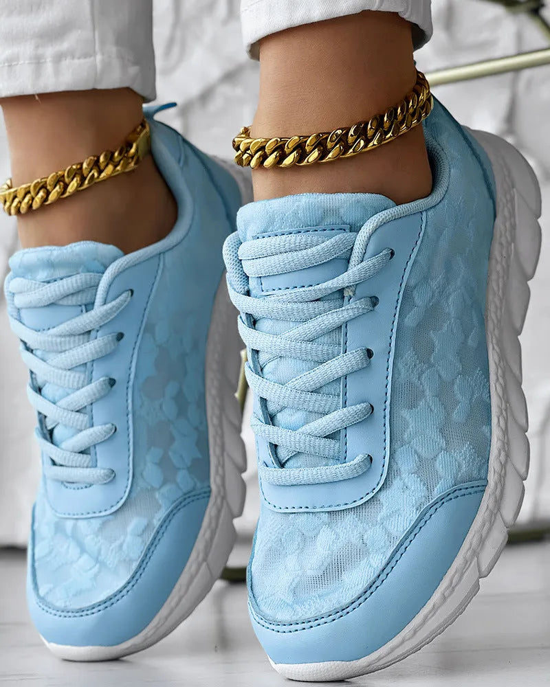 Women's white canvas casual running shoes with soft flat soles on a light background.