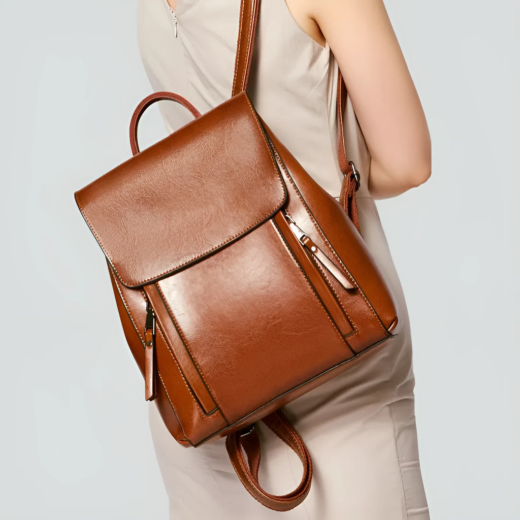 Large square black leather women's backpack with stitching and dual straps.