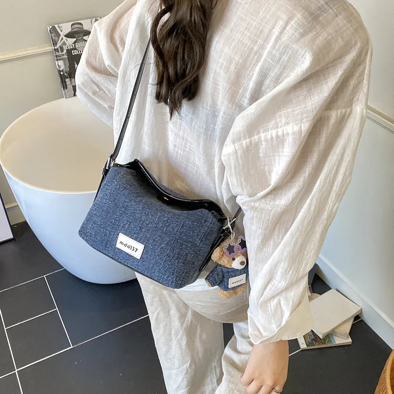 Denim small crossbody bag in black with slit pocket, horizontal square shape, medium hardness, polyester lining.