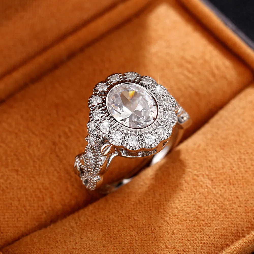 A geometric copper ring for women with a white gold coloured plating and a round zircon stone, shown on a finger.