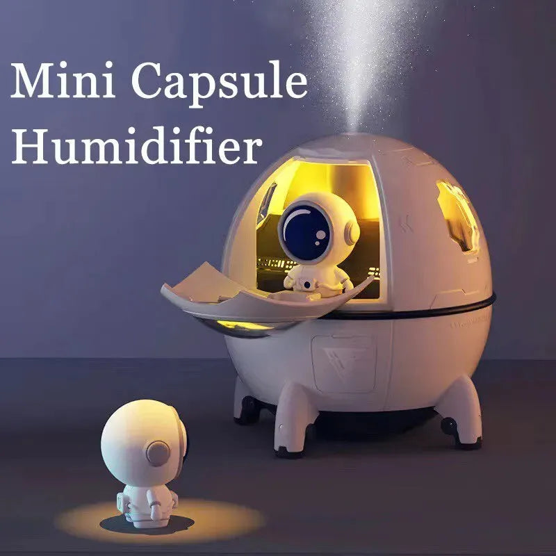 Astronaut-shaped USB desktop humidifier with colourful LED light on a desk.