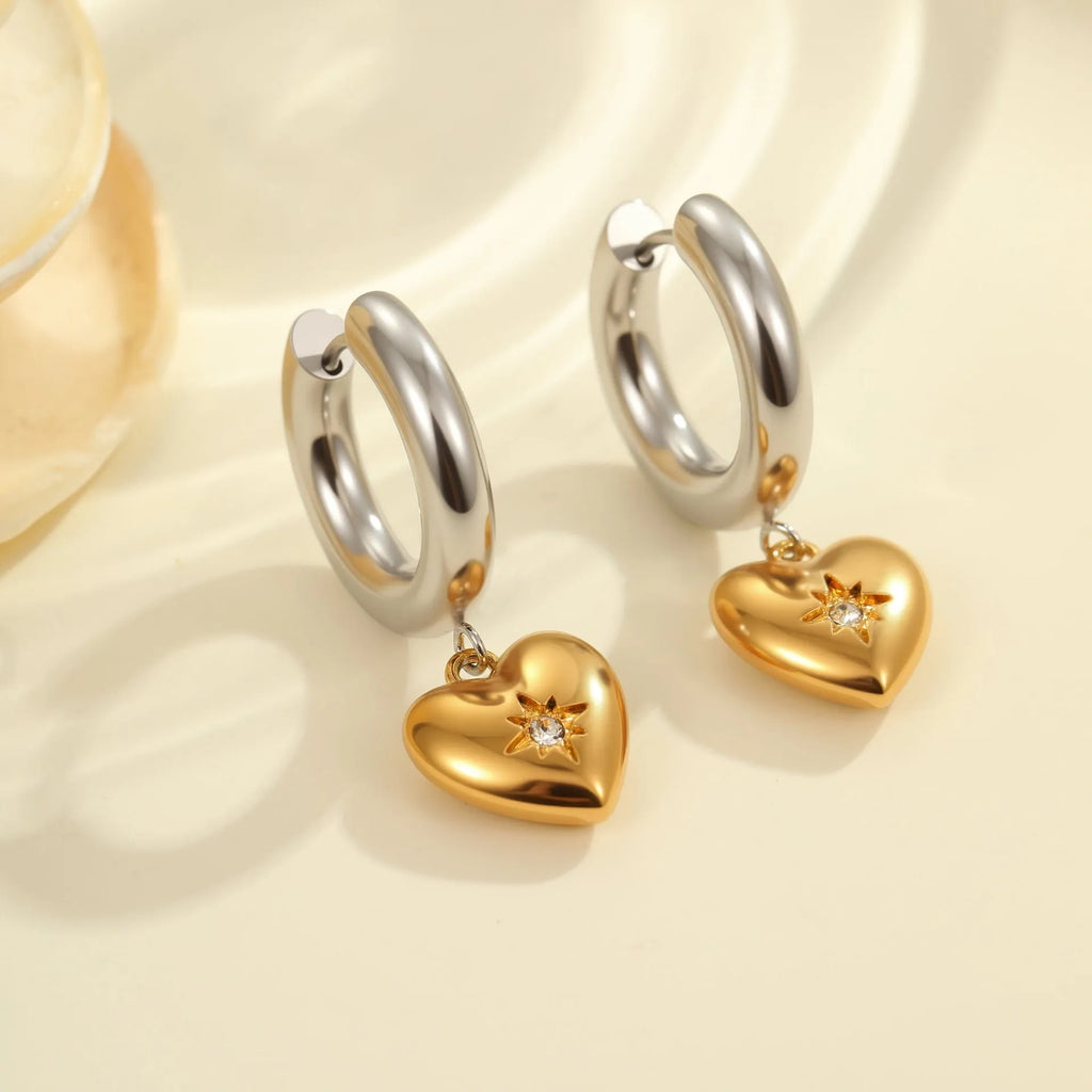 A pair of stainless steel earrings with 18K gold plating in a Christmas tree and heart shape design.