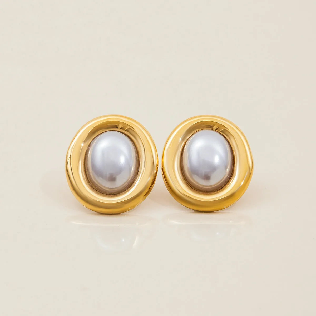A pair of stainless steel vintage pearl ball stud earrings with surgical steel posts on a white background.