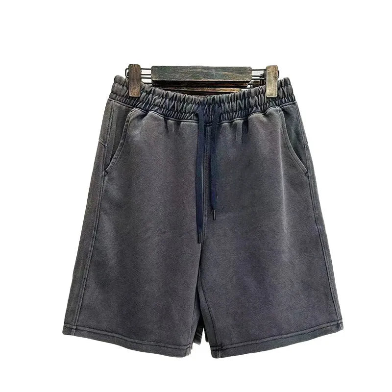 Man wearing navy blue distressed-style casual cotton shorts with a loose straight leg fit.