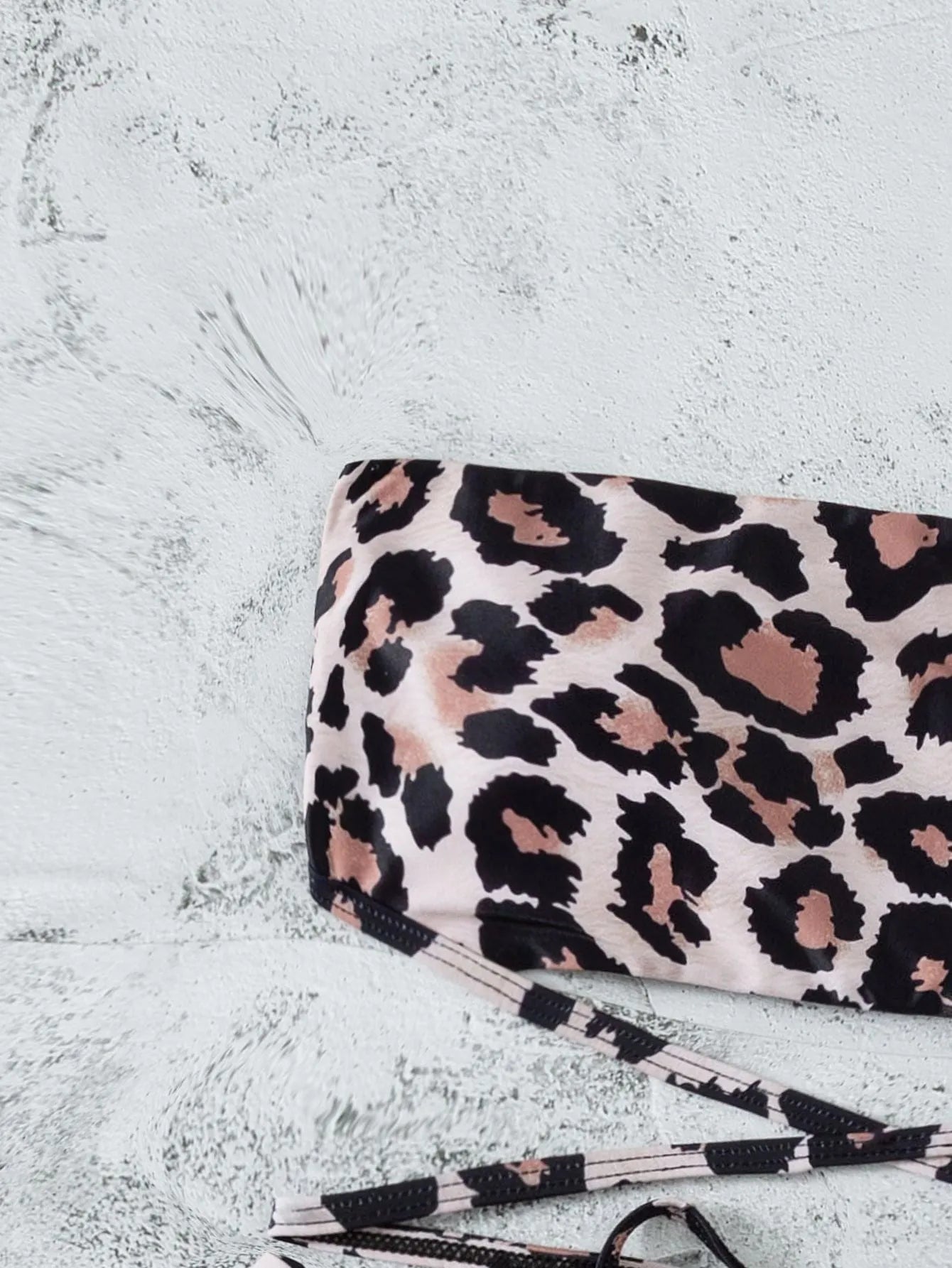 Leopard print bandeau split bikini swimsuit with removable chest pads on woman at beach