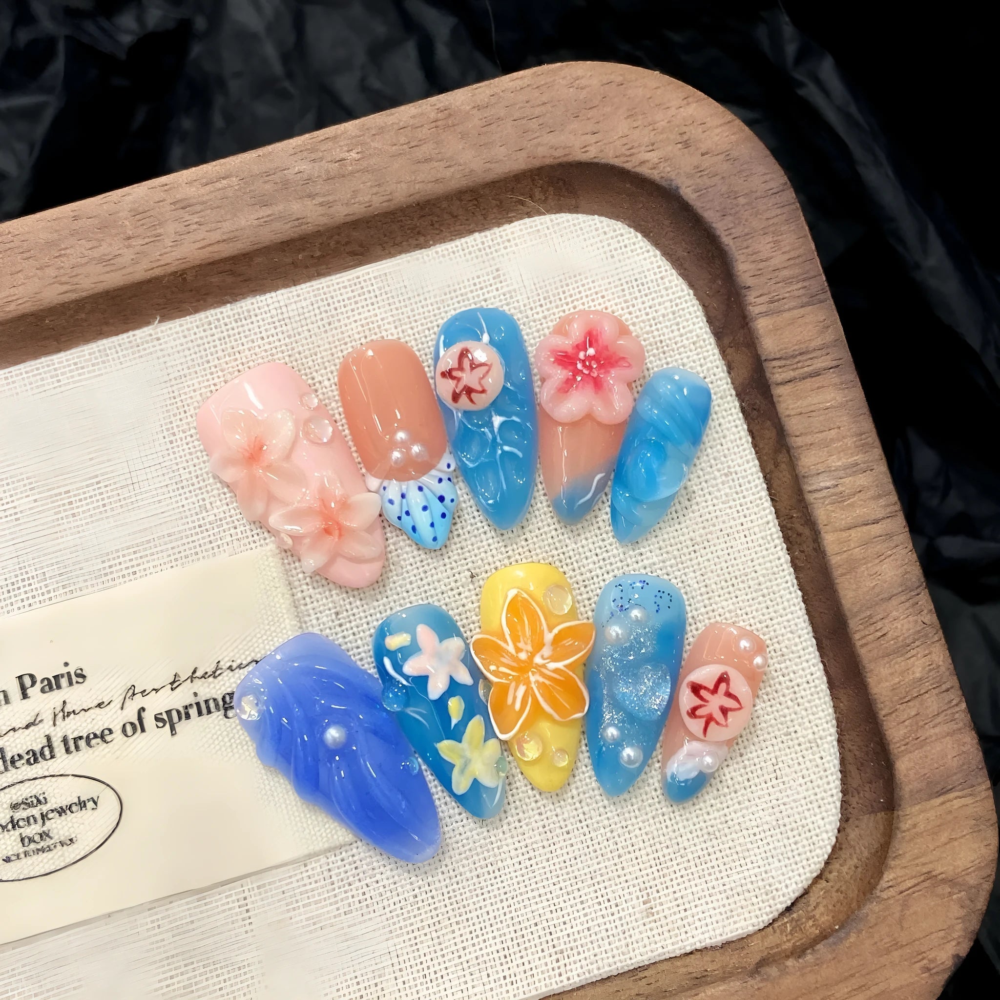 Three-dimensional carved jellyfish marine style plastic wearable armour in almond nail colour with rose, tulip, and XINGX patterns
