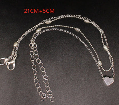Double-layered anklet with retro beach ball chain and heart-shaped charm in gold and silver