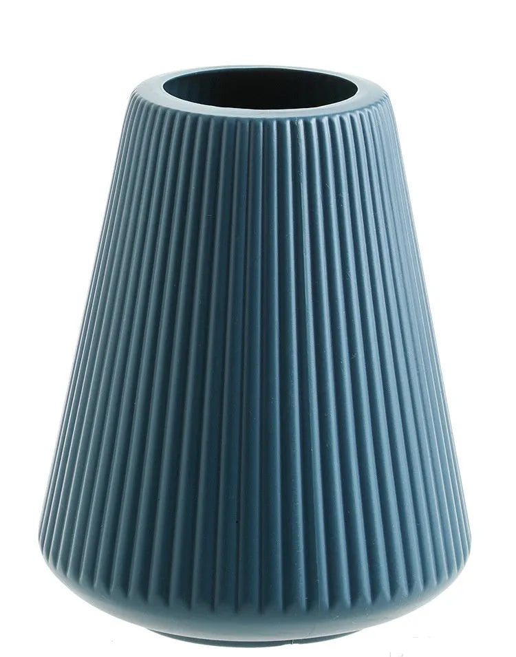 Colourful melamine plastic decorative flower vase on a desk, showing white, pink, green, and blue colour options.