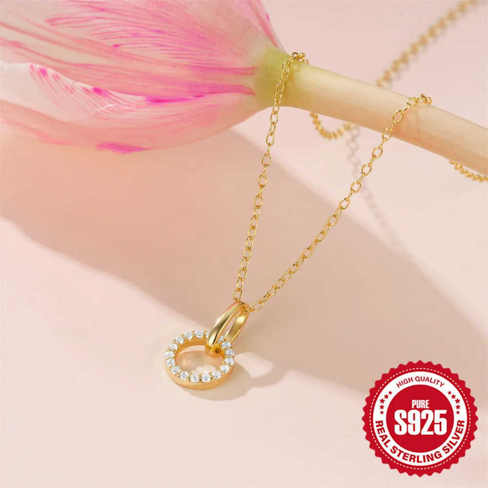 Gold geometric pendant necklace on a model, showing the interlocking design and adjustable clavicle chain.