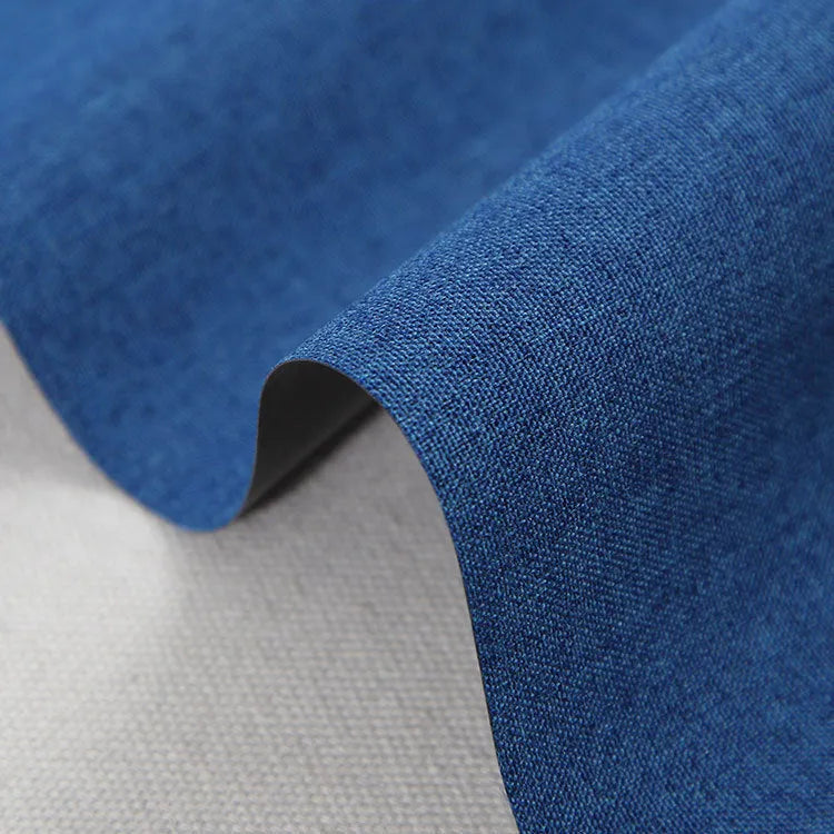 A black, blue, and green polyester ant cloth laid flat, used as a protective cover on a piece of luggage.