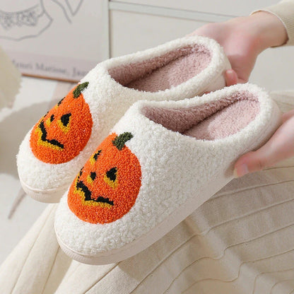 Cozy Halloween-themed pumpkin slippers in white and black colors, featuring soft suede uppers and durable rubber soles for indoor wear