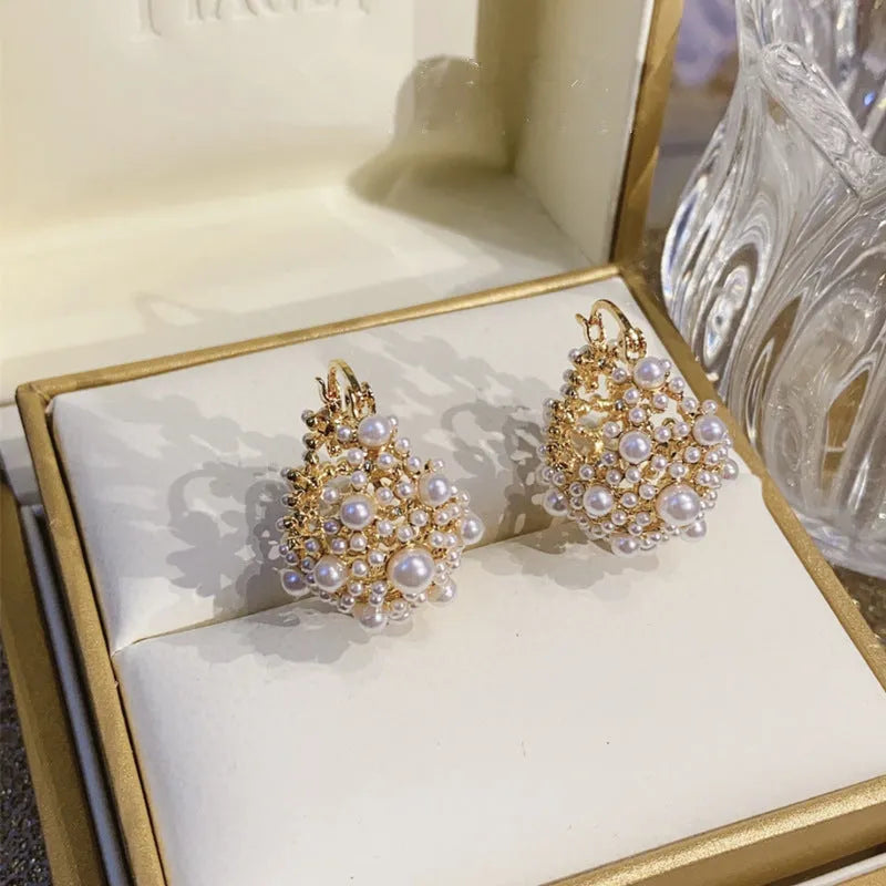 Gold-coloured copper flower basket earrings with small rice-shaped beads and pearl inlay details