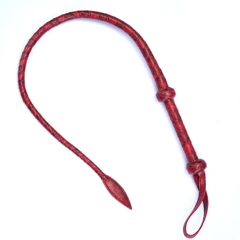 Red PU willow leaf whip for BDSM training and role play, lying on a surface.