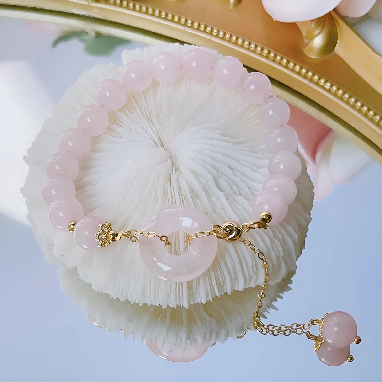 Pink crystal peace buckle bracelet on a metallic chain for women.