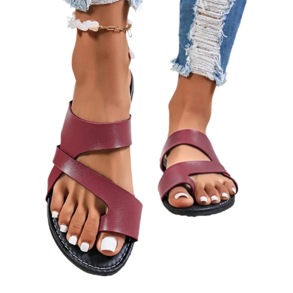 Pair of solid colour beach slippers with round toe and hollow-out pattern on the upper.