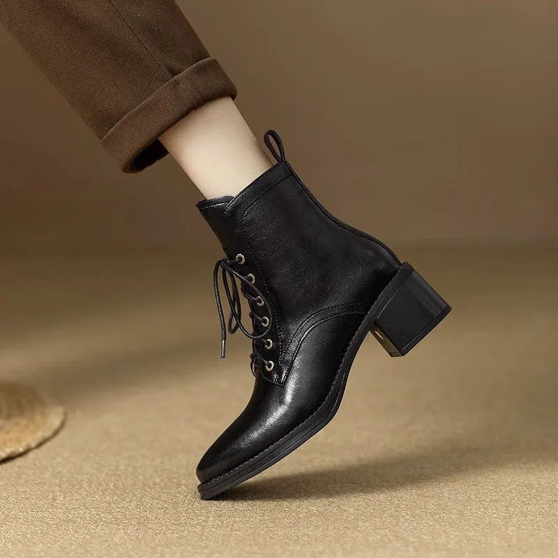 Women's black pointed-toe short tube boots with 5.5cm block heel on wooden floor