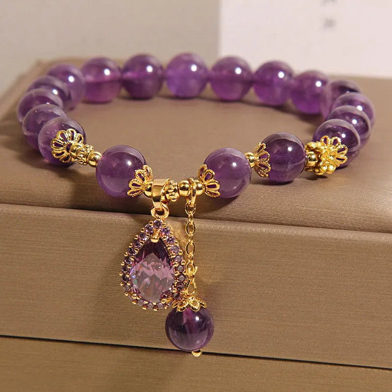 Natural amethyst bracelet with gold-plated inlay and purple droplet pendant on white background