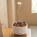 White portable simulated flame ultrasonic aromatherapy air humidifier with remote control on a table