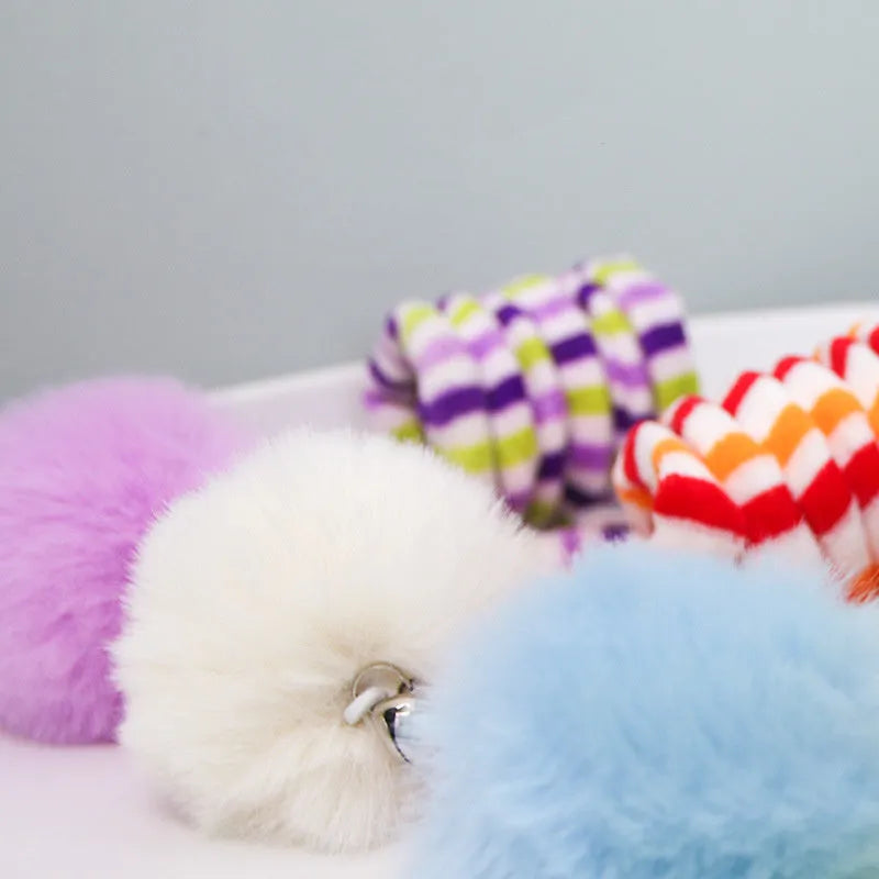 Colourful cat toy with inflatable ball and bell stick hanging from suction cup on door