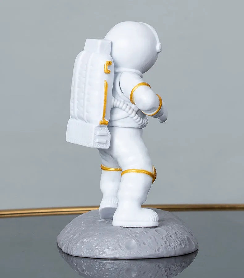 Plastic astronaut decoration mobile phone holder in blue colour on a desk