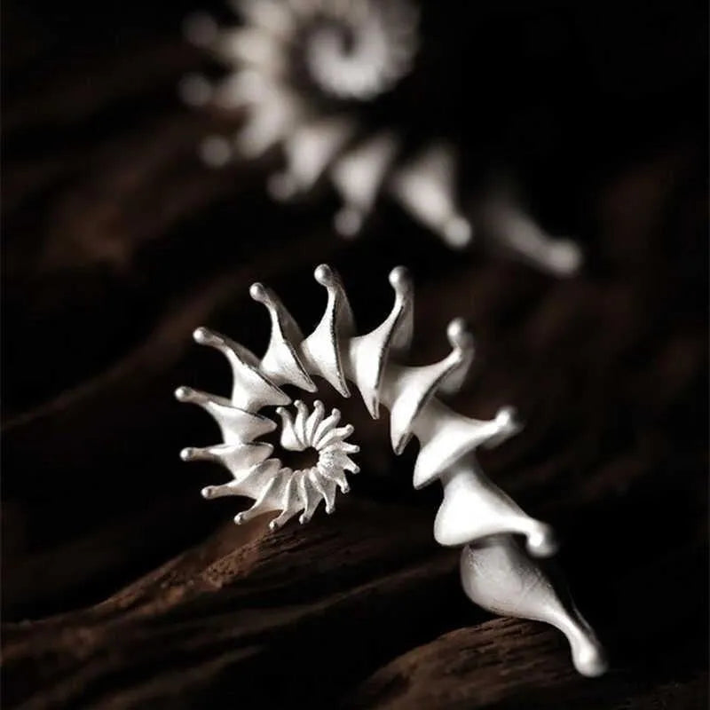 A pair of matte finish conch stud earrings with a three-dimensional, irregular alloy design.