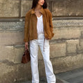 Solid colour loose-fit retro jacket with long sleeves on a hanger.