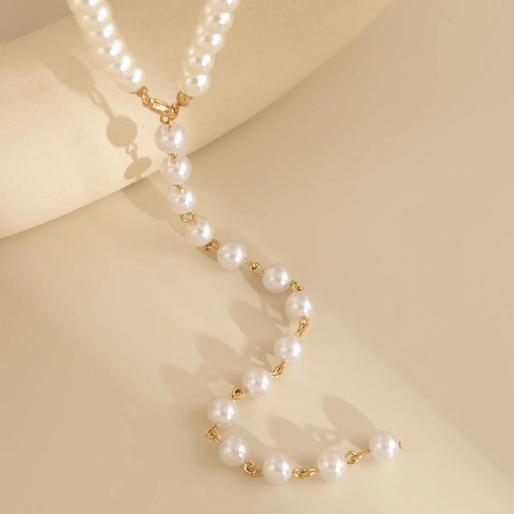 Round beads imitation pearl necklace on display showing gold colour metal chain