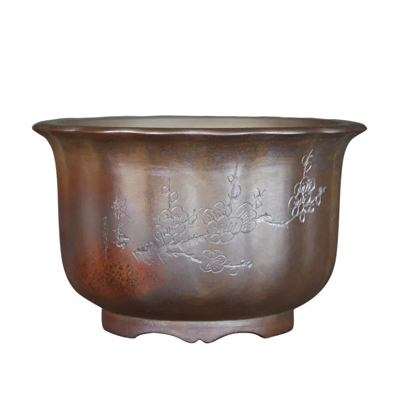 Indoor antique carved purple sand ceramic flowerpot in S1696 firewood colour on a wooden surface.