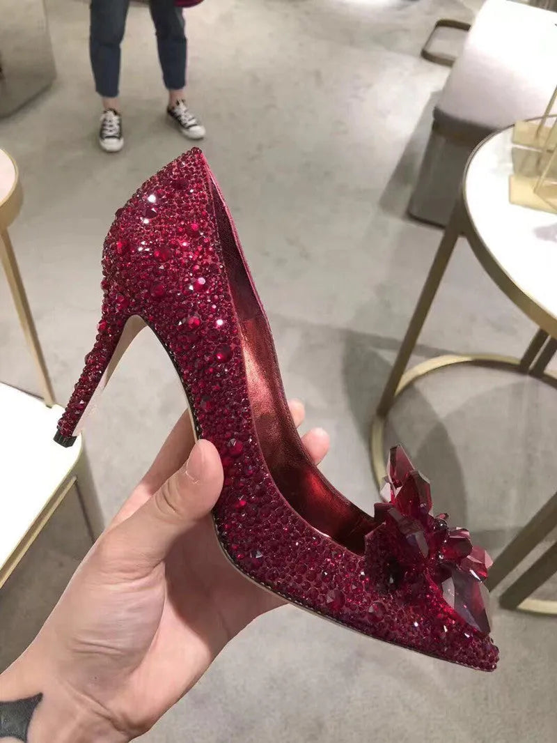 Women's gold sequinned pointed toe high heels with rhinestone details and a stiletto heel.