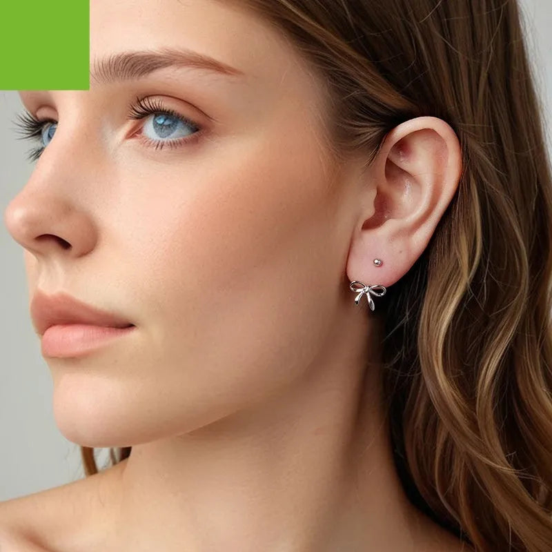 Women's S925 sterling silver bow stud earrings, polished silver finish, 1.2 cm bow shape on white background