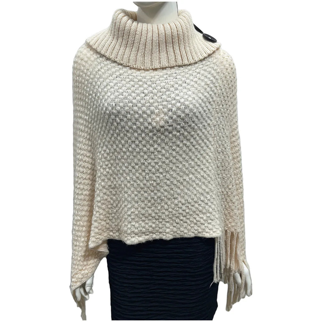 Sleeveless dot pattern knit cloak poncho in apricot colour, laid flat.