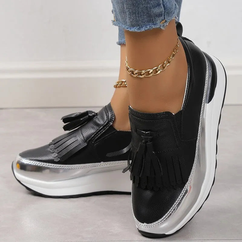 Black women's casual platform shoes with tassel detail and a distinctive English muffin wedge heel.