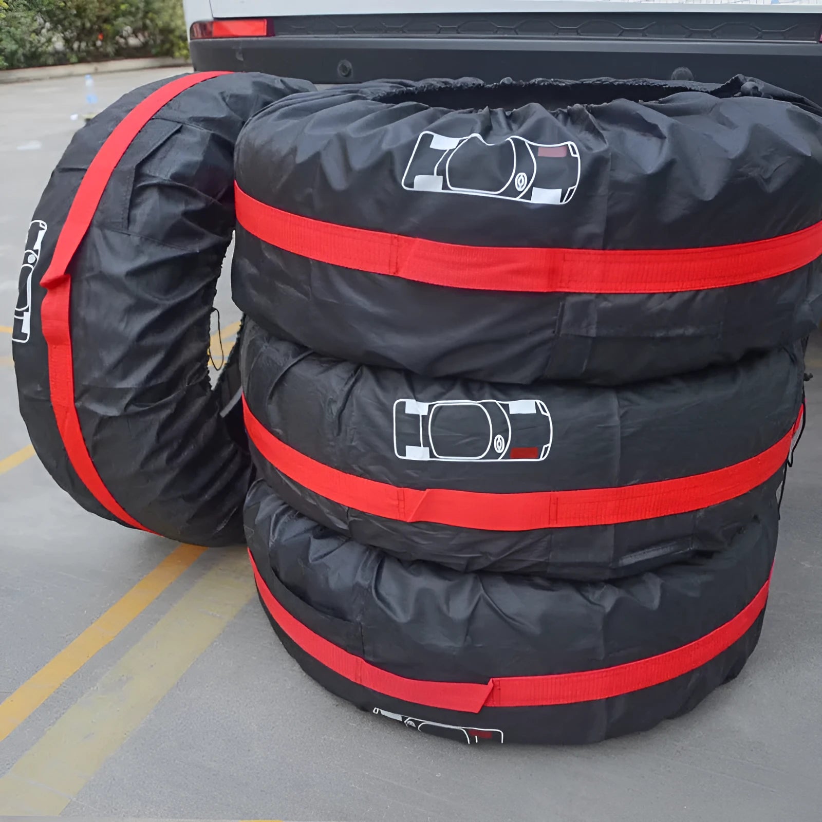 Four black Oxford cloth tyre protective covers laid flat, showing their circular shape and belt-style detailing.