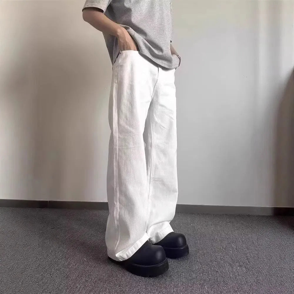 Men's white straight-leg cotton denim jeans on a hanger, showing the mid waist and wide leg opening.