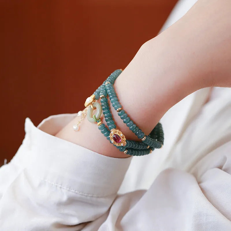 Blue water jade abacus bead bracelet with tourmaline and pearl accents on a wrist