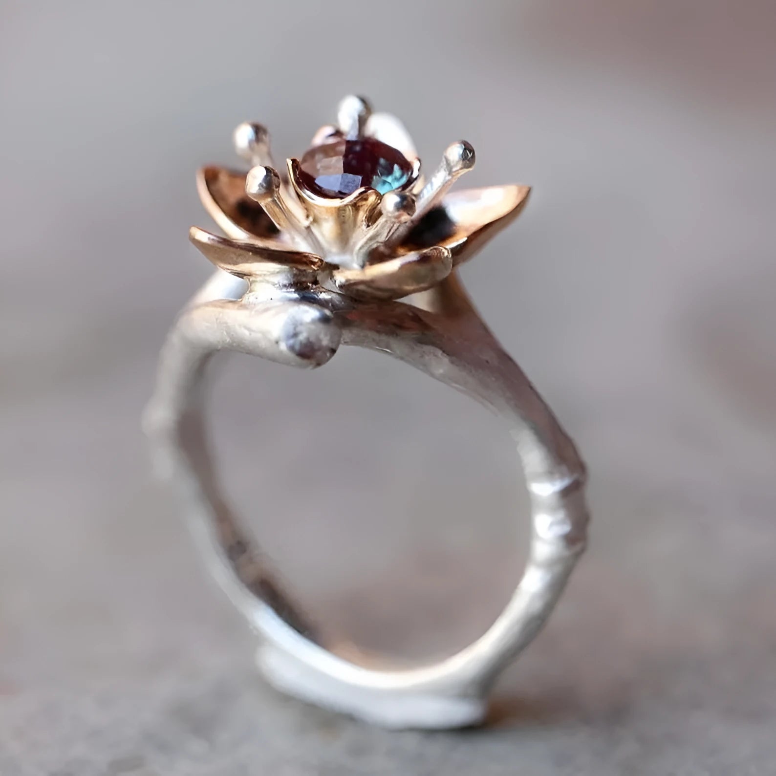 Silver two-tone floral pattern geometric alloy fashion ring for women on a grey background.