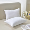 White cotton satin stripe feather and cotton pillow shown in a simple style on a bed.