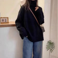 Women's loose thick grey turtleneck sweater with curling pile collar, casual pullover style.