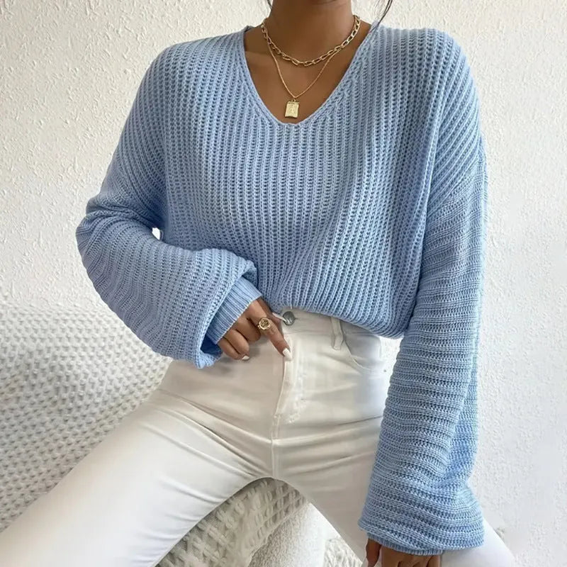 A woman wearing a solid colour long sleeve loose pullover top in a casual setting.