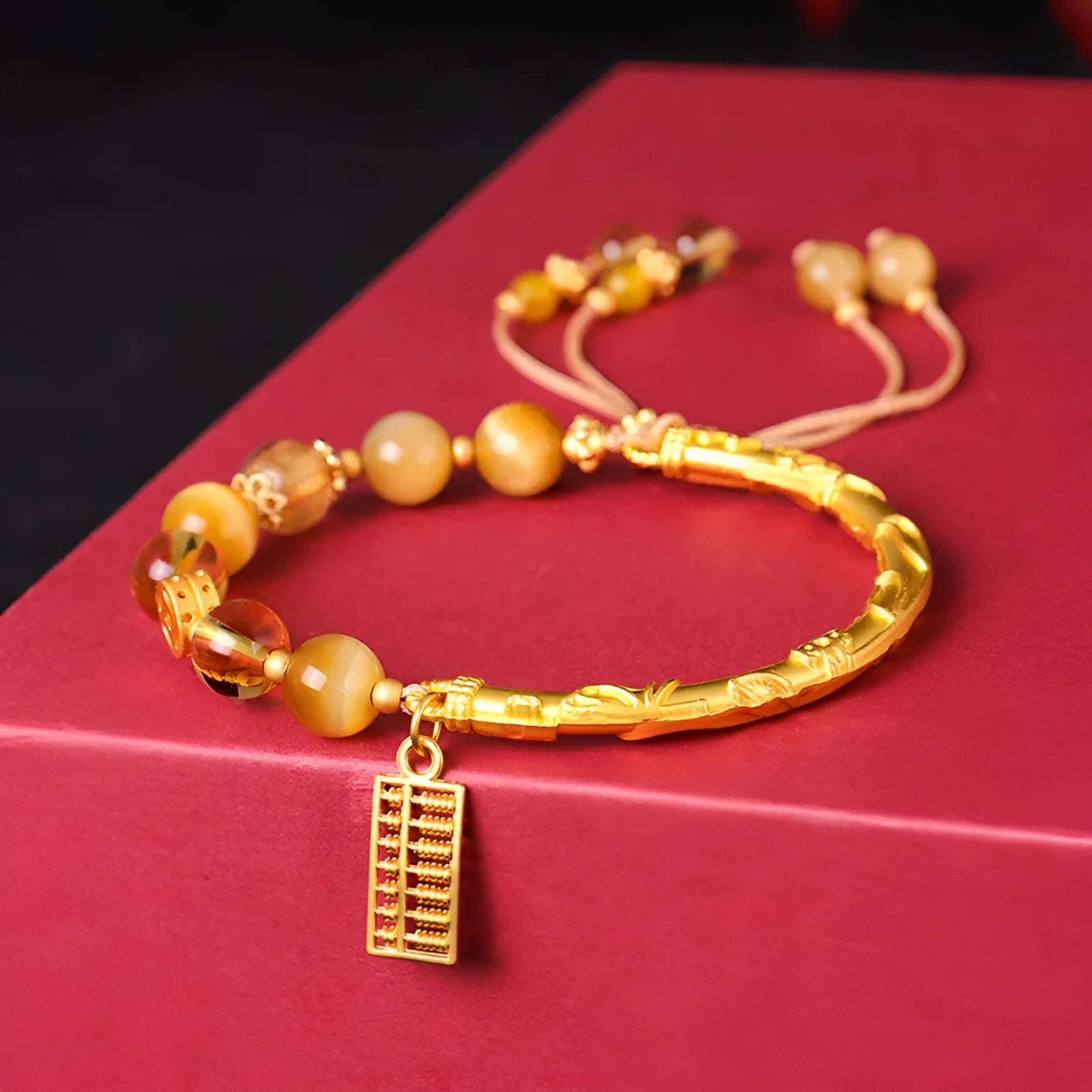 Close-up of a women's beaded bracelet with a diamond-shaped abacus tag bead, tigereye, citrine, and yellow tower crystal stones on copper.