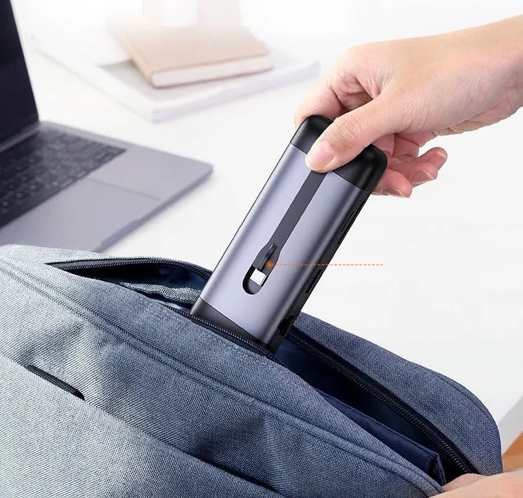 A compact USB-C hub adapter with short cable, showing HDMI, USB 3.0, Power Delivery, and other ports.