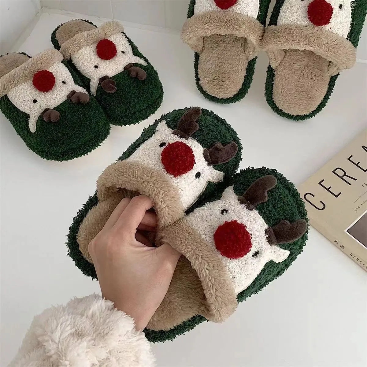 Women's green plush Christmas elk slippers with non-slip PVC sole, shown on a white background.