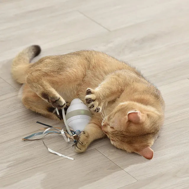 Gray 360 rolling mouse cat toy with feather tease on a floor