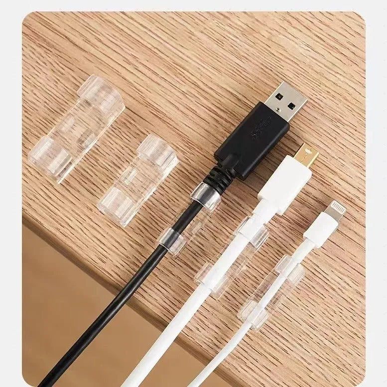 Transparent self-adhesive plastic cable management clips in four sizes on a white background.