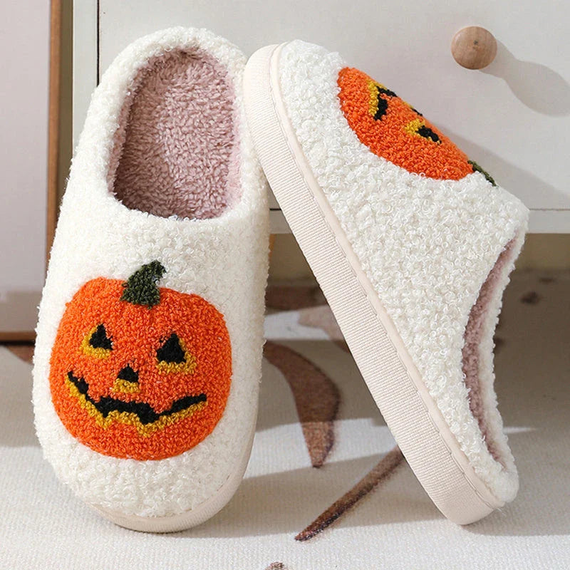 Cozy Halloween-themed pumpkin slippers in white and black colors, featuring soft suede uppers and durable rubber soles for indoor wear