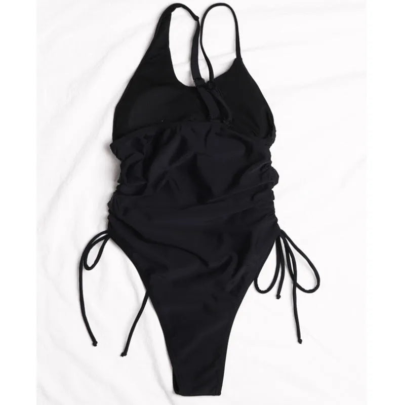 Black tight-fitting women's dress with sloping shoulder design and lacing detail