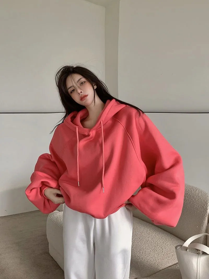 Watermelon red women's loose mulberry silk hooded sweater on a hanger.