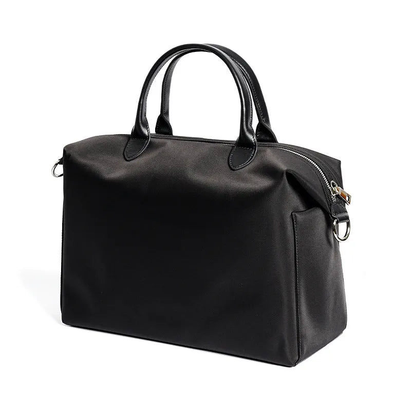 Black nylon waterproof shoulder bag with leather trim showing large main compartment