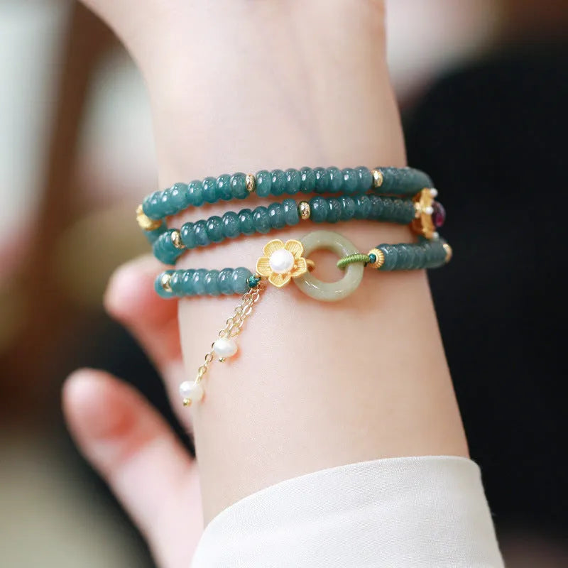 Blue water jade abacus bead bracelet with tourmaline and pearl accents on a wrist