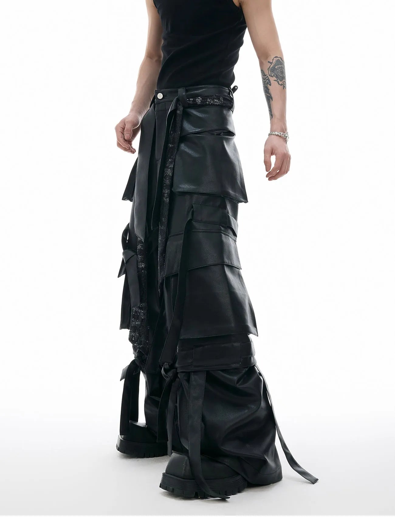 Black loose-fit leather-look trousers with multiple pockets, quilted panels, and ribbon trim details.